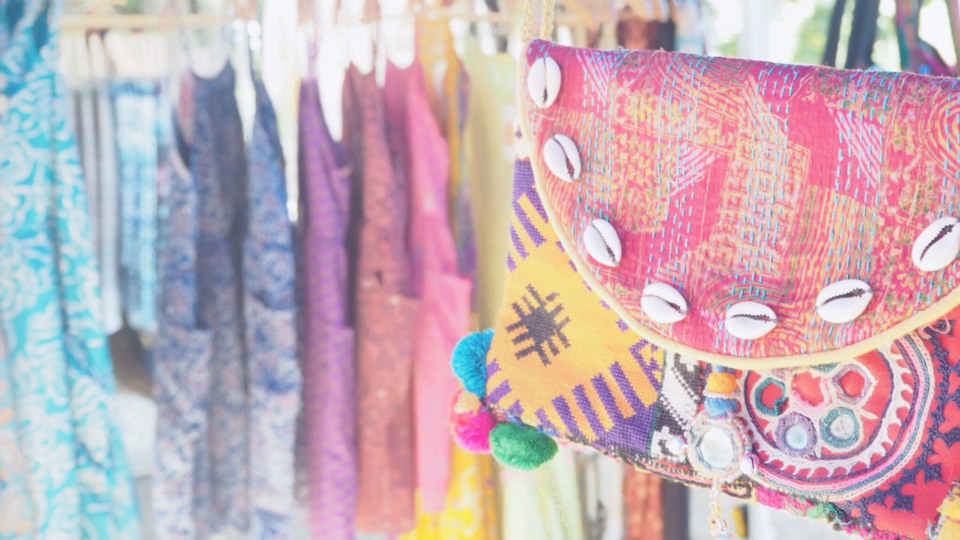 色とりどりの布を使った小物や洋服などが飾られているマーケットの店頭