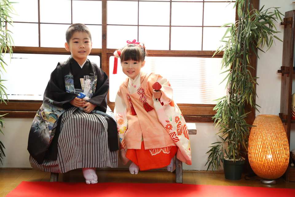 東京都文京区千駄木の古民家写真館ケープルヴィルのフォトスタジオで、３歳と５歳の七五三の衣装をきた兄弟が窓際に座っていて、たのしそうに写真を撮っているようす。
