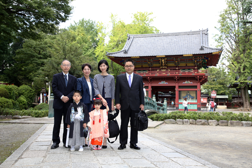根津神社の境内で、おじいちゃん、おばあちゃん、ご両親、おこさまが全員集合して記念撮影。東京都文京区千駄木のケープルヴィル写真館のフォトグラファーは、出張撮影もいたします。