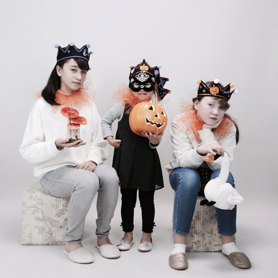 シュールなハロウィーンの仮装写真。かぼちゃと一緒に３人の女の子たち。