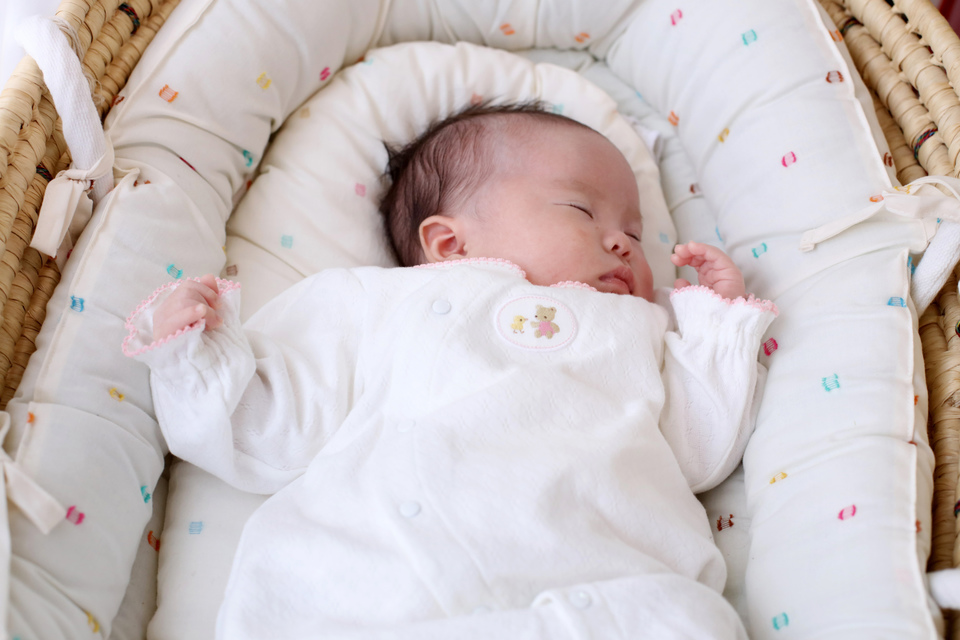 すやすやと眠るあかちゃん。ケープルヴィル2Fの写真スタジオでみんなに見守られてのお宮参り撮影。